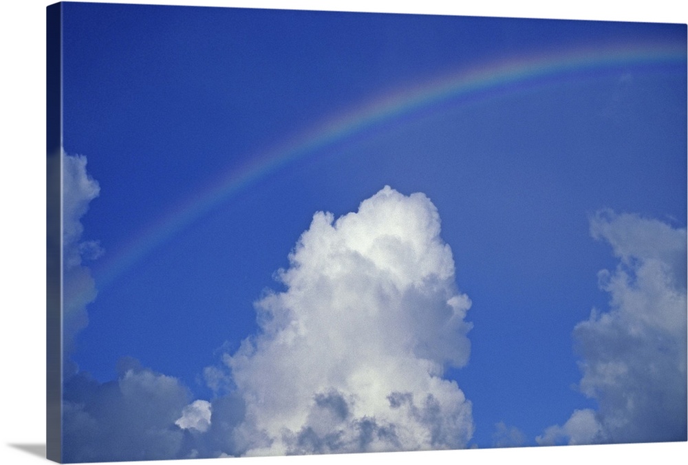 Hawaii, Rainbow arching over clouds in blue sky