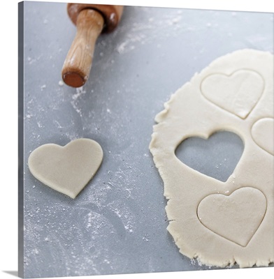 Heart shape cut out of a sheet of rolled out cookie dough