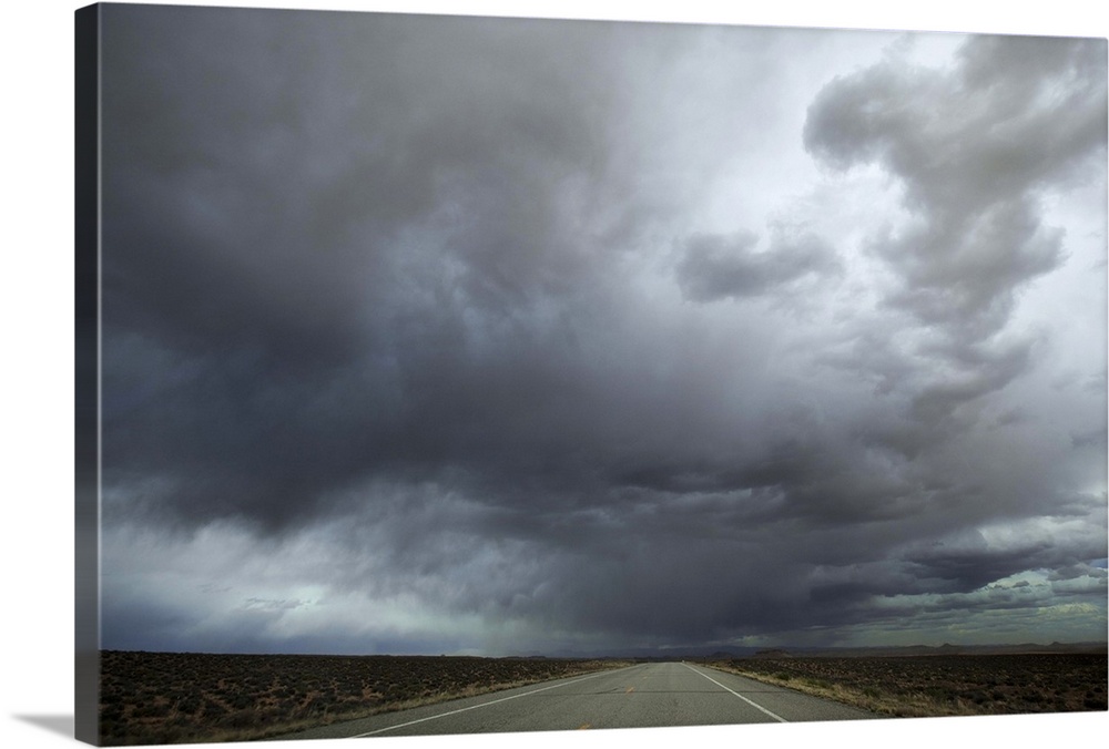 Long stretch of empty highway leading into a storm..