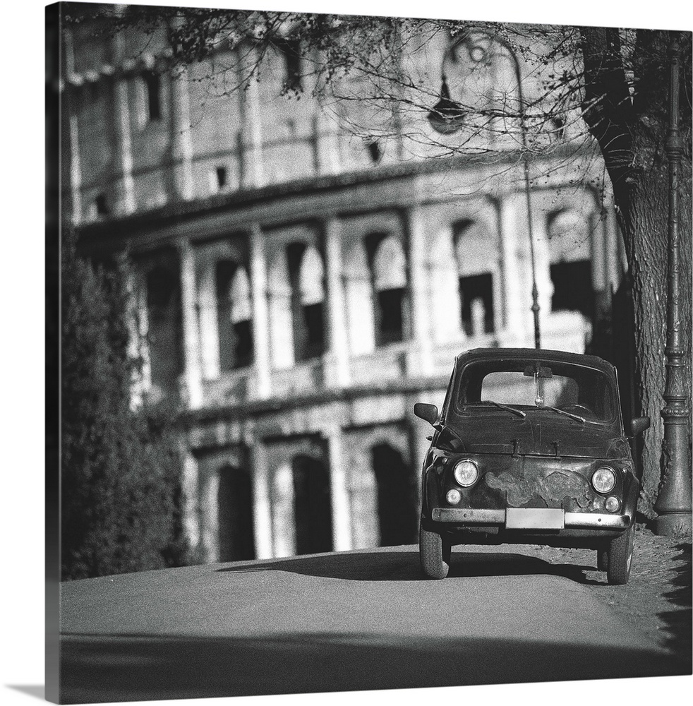 Black and white image of an old Italian car parked near the Colosseum.