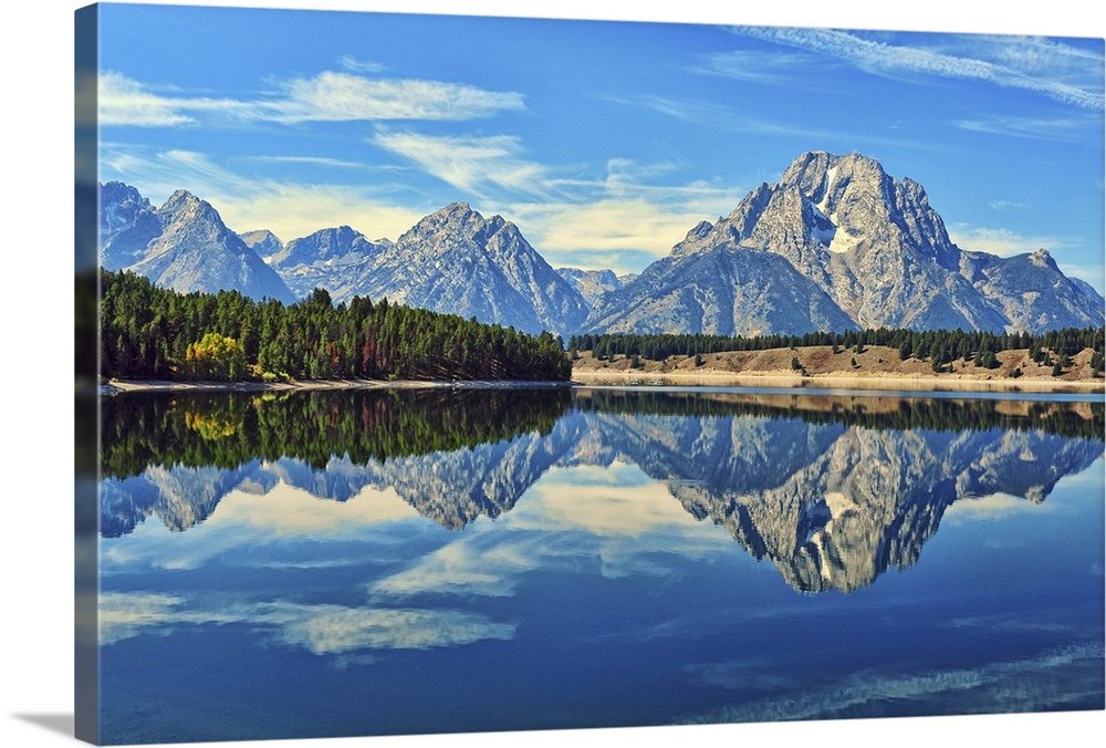 A reflection of Mount Moran and the Teton mountain range in the still waters of Jackson Lake in Grand Teton National Park,...