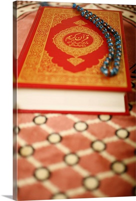 Koran and praying beads, placed on a praying carpet. Dubai, United Arab Emirates
