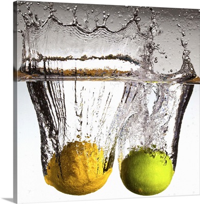 Lemon and lime falling in water.