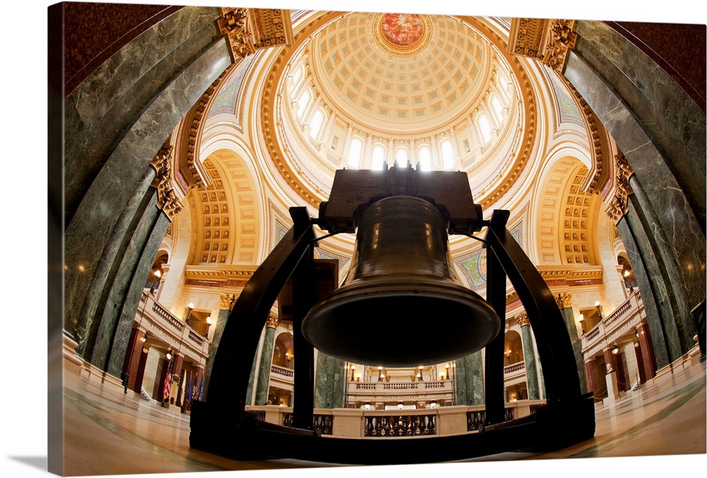 Replica of Liberty Bell rests beneath massive dome inside ornate State Capitol building.