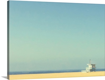 Life guard tower on beach with blue ocean and blue sky.
