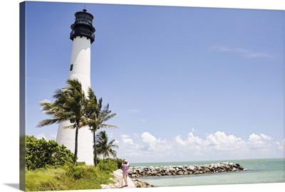 Lighthouse and tropical palm trees near ocean