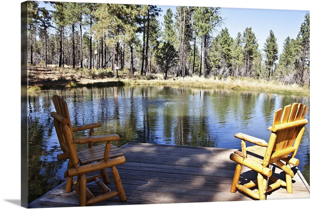 Log chairs on deck overlooking small pond with Ponderosa pine trees.