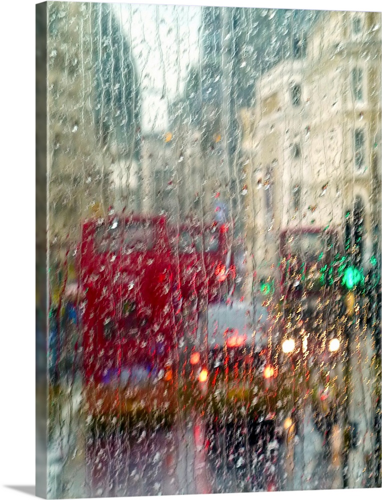 View of red double Decker buses and yellow taxis in rain in London Piccadilly Circus.