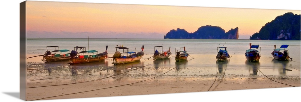 Long tail boats on beach at sunset.