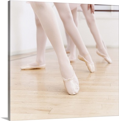 Low Section of Three Girls in Ballet Shoes Standing With Their Leg Pointing out