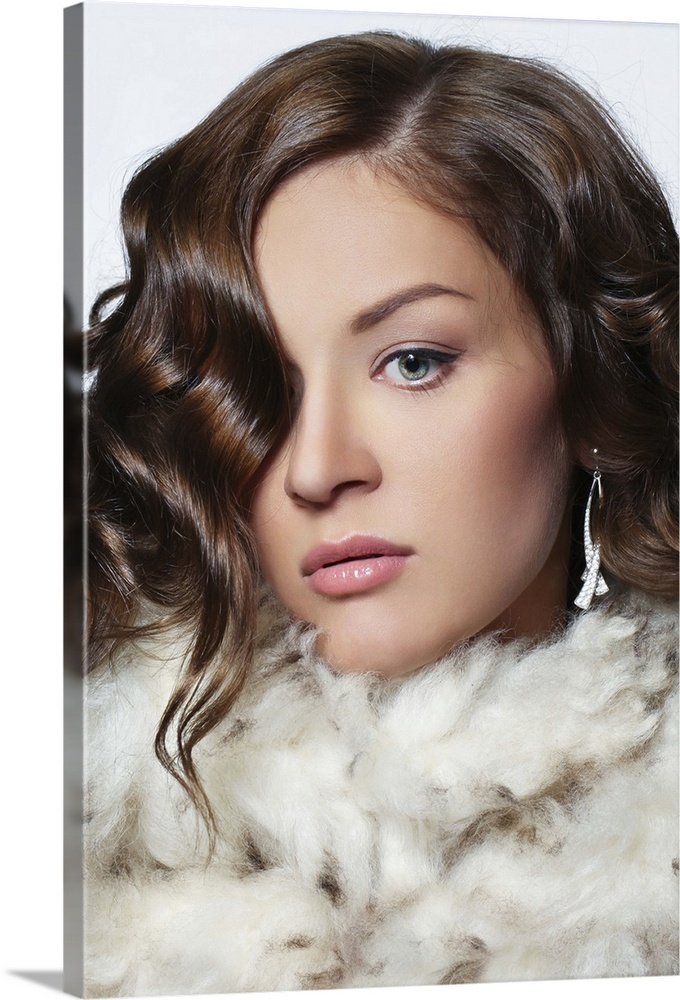 Fashionable portrait of beautiful young woman wearing fur, professional make-up and hairstyle