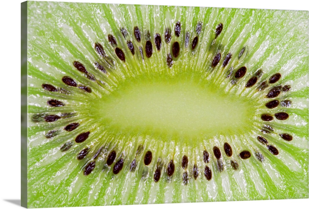 Large closeup photograph of the inside of a sliced kiwi fruit.