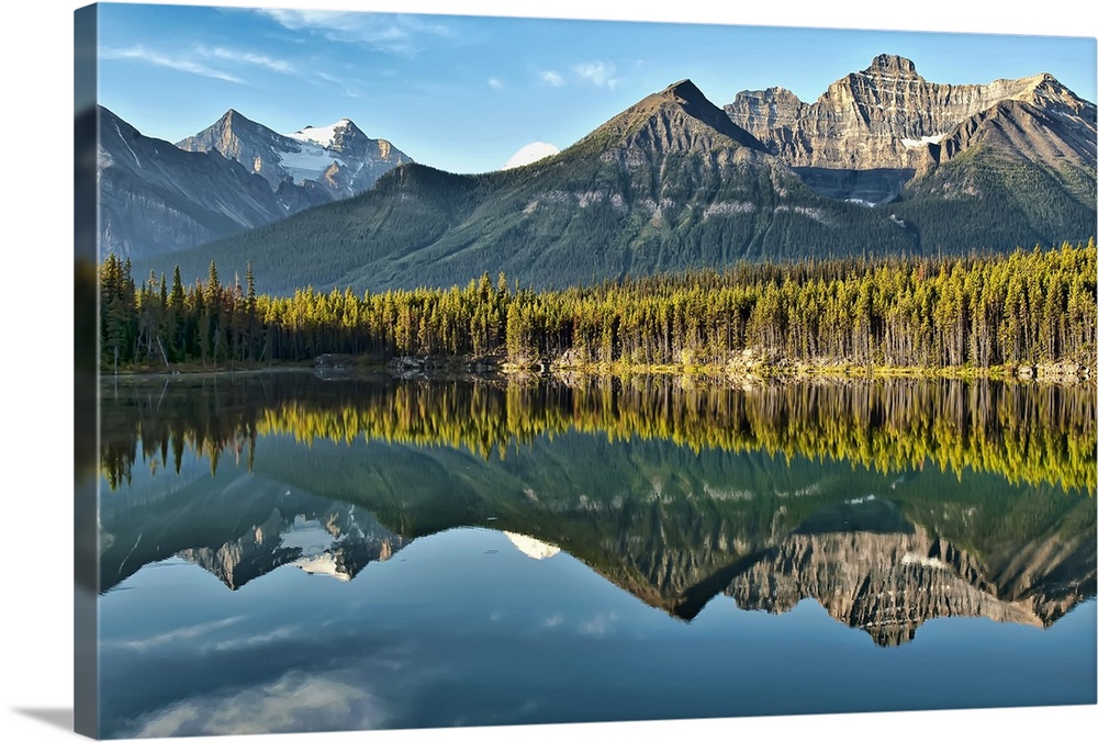 Magical mountain reflection of Canadian Rockies in Herbert Lake on peaceful morning in Banff National Park.