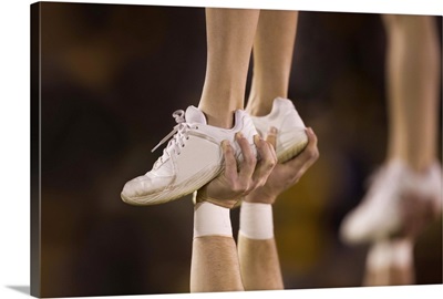 Male cheerleader holding up female cheerleader