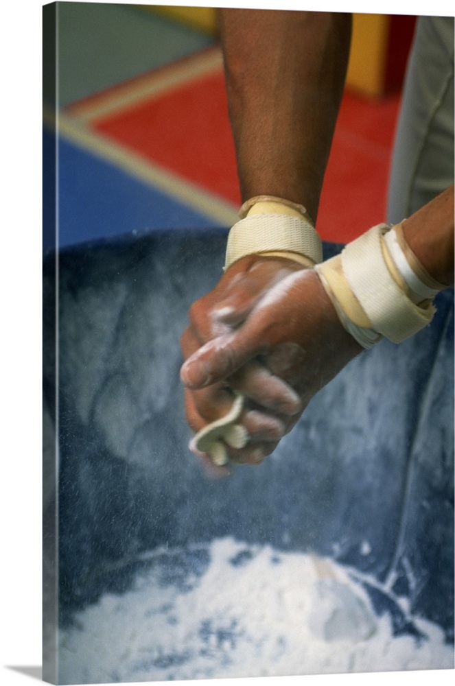 Male gymnast rubbing chalk on hands