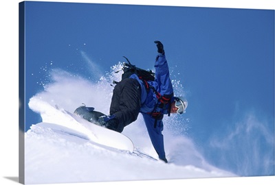 Male snowboarder leaning into slope, low angle view