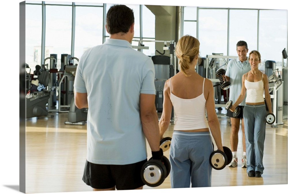 Man and woman lifting hand weights in front of a mirror