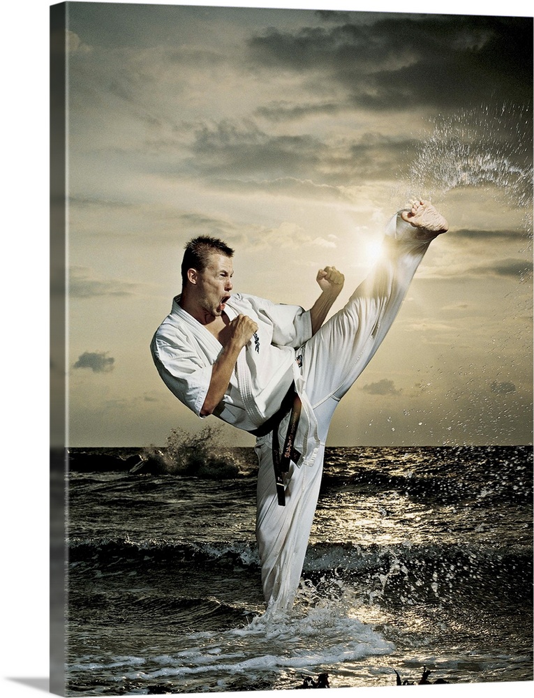 Man doing karate kick in the ocean
