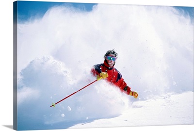 Man downhill skiing in cloud of powdery snow