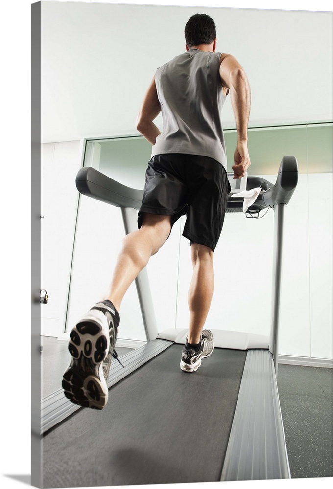 Mixed race man running on treadmill