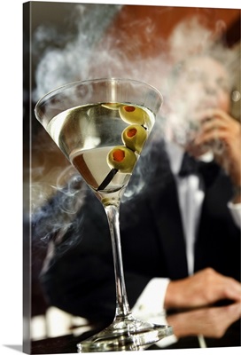 Man smoking cigar with martini on bar