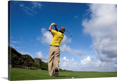 Man swinging golf club, rear view