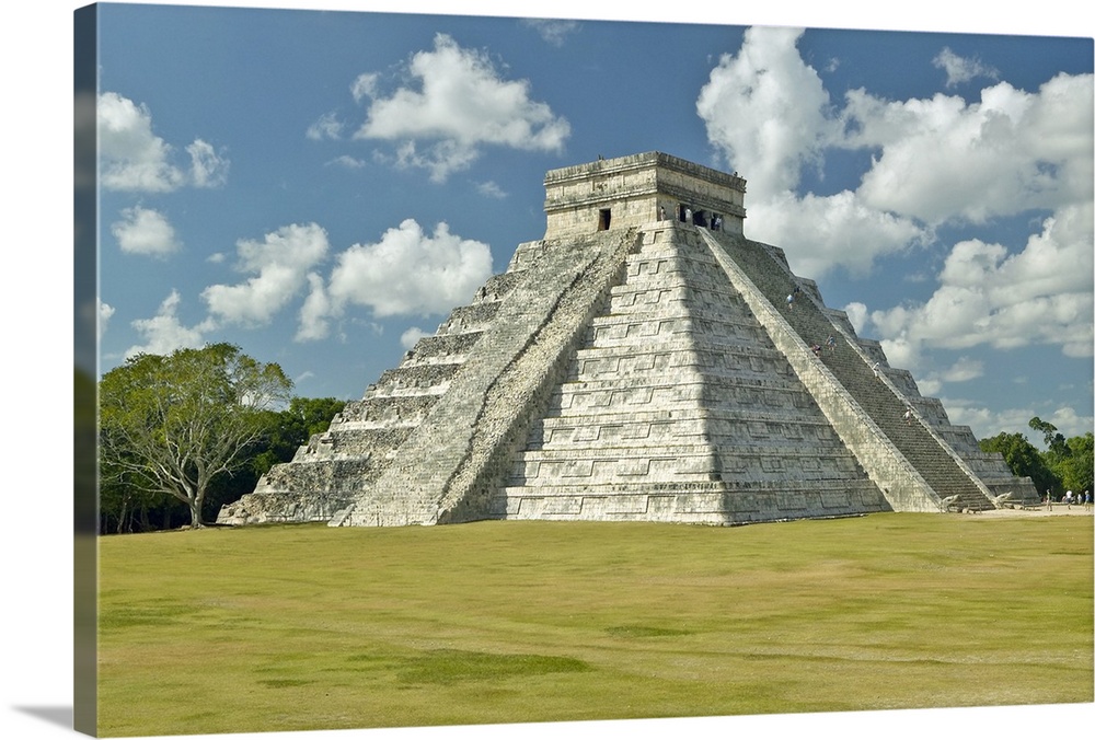 White puffy clouds over the Mayan Pyramid of Kukulkan (also known as El Castillo) and ruins at Chichen Itza, Yucatan Penin...