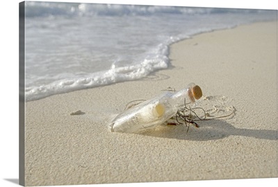 Message in bottle lying on beach, (close up), close-up