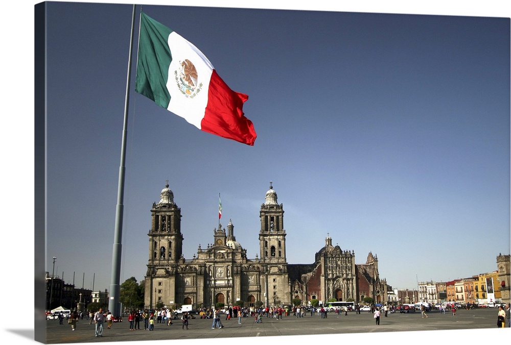 Mexico City cathedral framed under the huge flag, at the Zocalo square, also called Plaza de la Consitucion.  The flag is ...