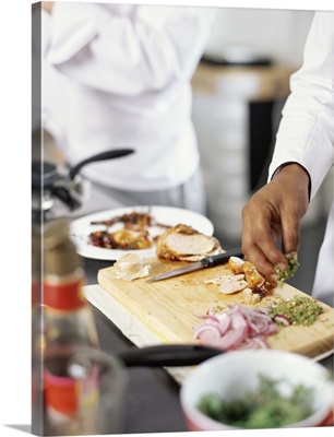 Mid section view of two chefs cooking food in the kitchen