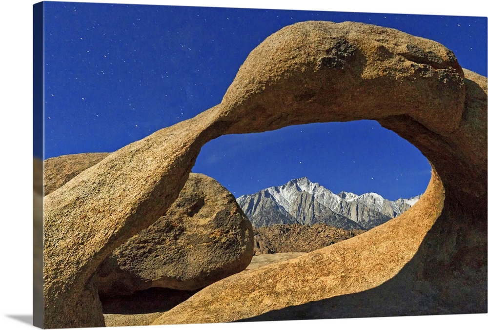 Lone Pine Peak framed by Mobius Arch illuminated by light of moon in star-filled sky, in Alabama Hills, near Lone Pine, Ca...
