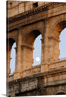 Moon framed by the arches of the Colosseum in Rome, Italy