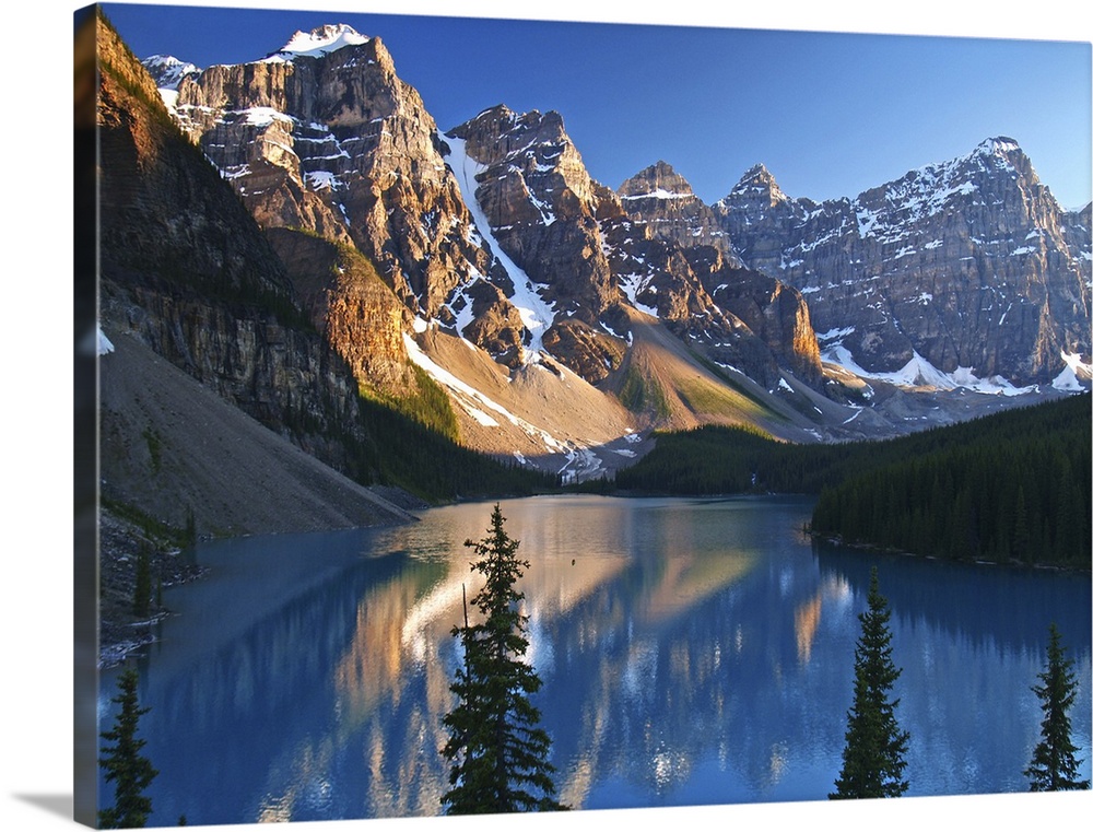 The azure blue waters of Moraine Lake in Banff, Canada surrounded by the towering snow-capped mountains of the Ten Peaks