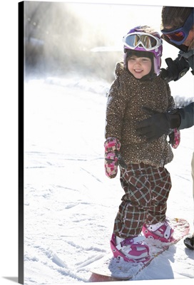 Mother Teaching Daughter To Snowboard