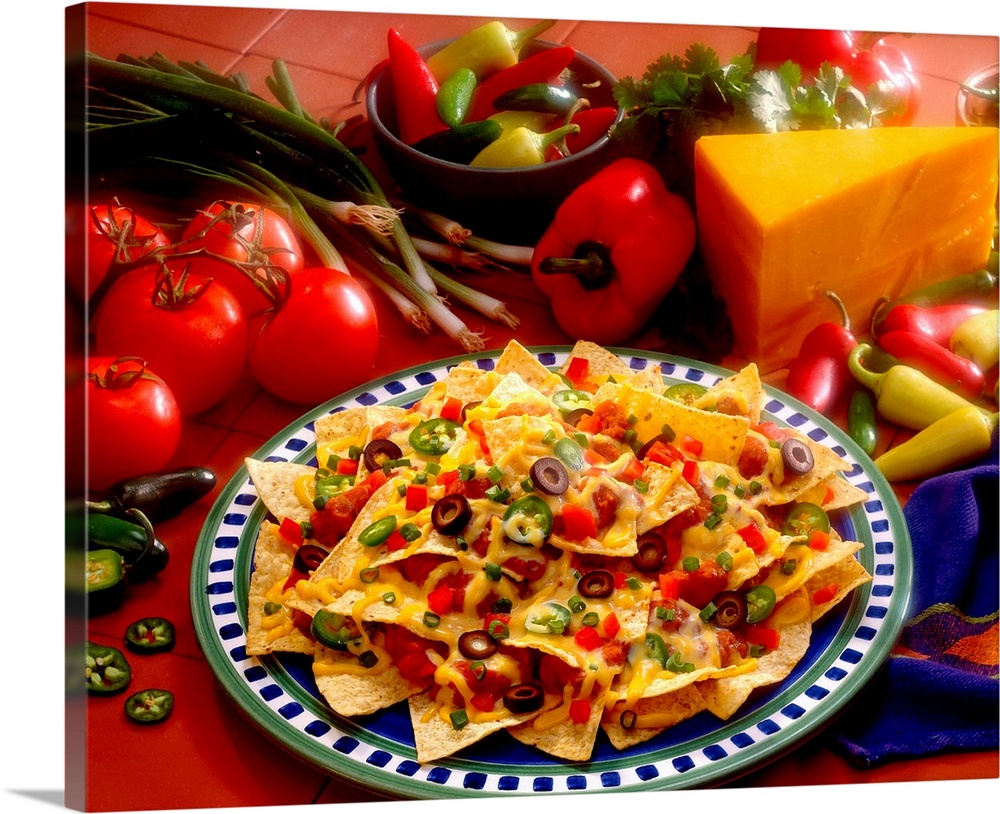 Horizontal photograph on a big canvas of a plate of loaded nachos, the fresh ingredients used on them are also surrounding...