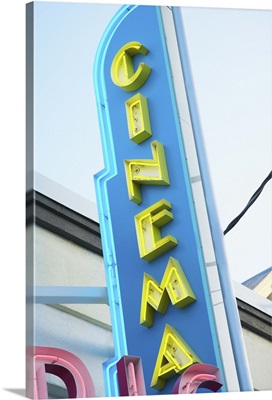 Neon cinema sign on building during day