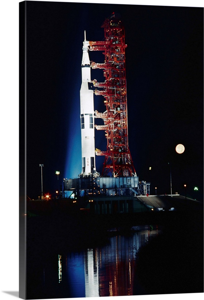 Cape Kennedy, Fla.: The moon passes behind the brilliantly lighted Apollo 17 spacecraft as it sits on its launch pad in th...