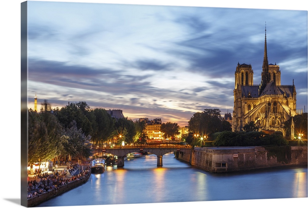 View of Notre Dame and Seine river at dusk in Paris.