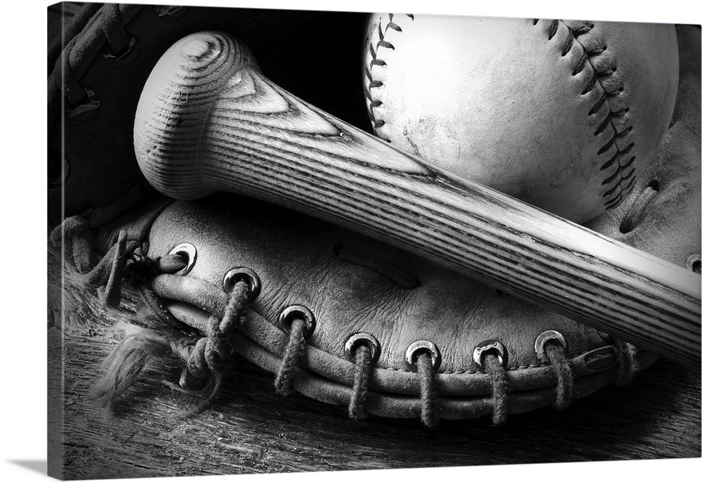 A black and white image of an old baseball glove and bat.