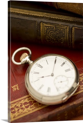 Old-fashioned pocket watch and books