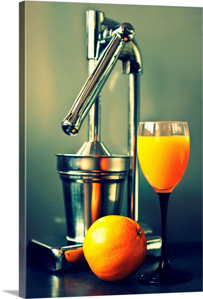 Orange juice in glass, juicer and orange.