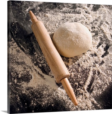 Overhead shot of a rolling pin, dough and flour on a counter