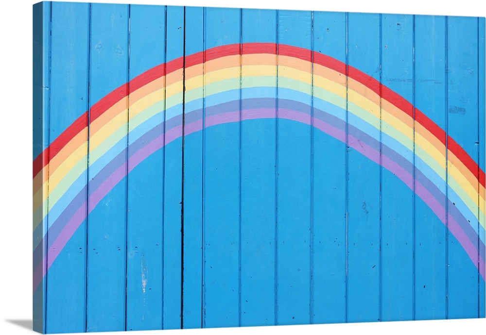 Painted rainbow on wooden fence.