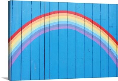 Painted rainbow on wooden fence.