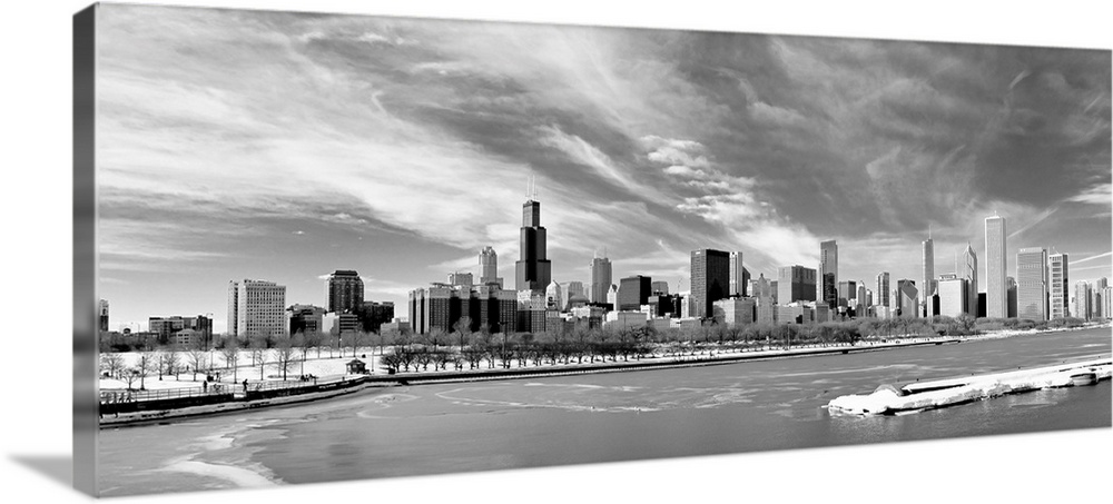 Landscape photograph on a large canvas of the Chicago skyline during winter, beneath a sky of wispy clouds, the waters in ...