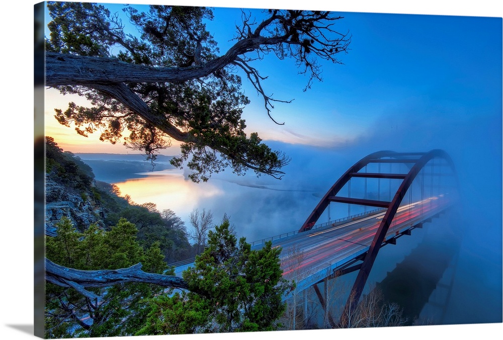 Large photograph displays an overpass on the Colorado River in Austin, Texas while a large mist flows over top of it.  Pho...