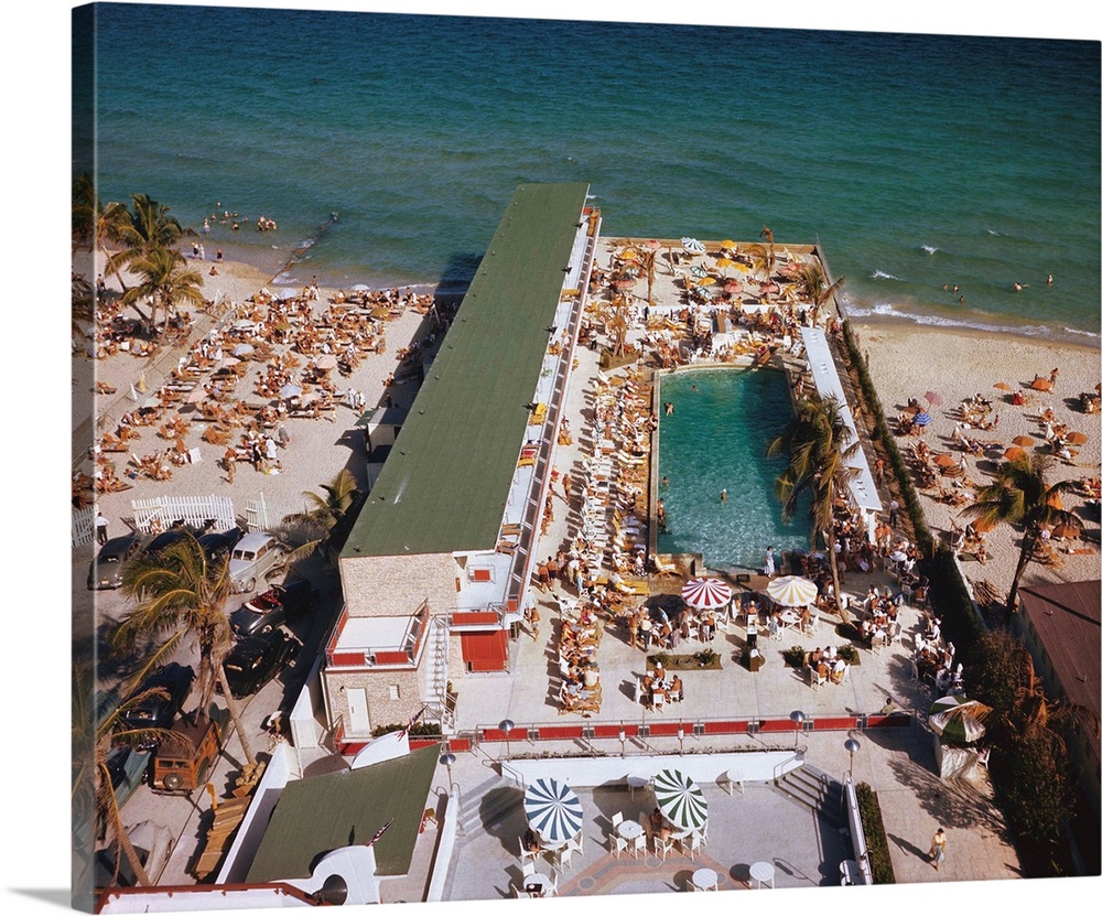 The Delano Hotel Pool in Miami Beach, Florida, with it's double deck cabanas. Patio in the foreground with colored umbrell...