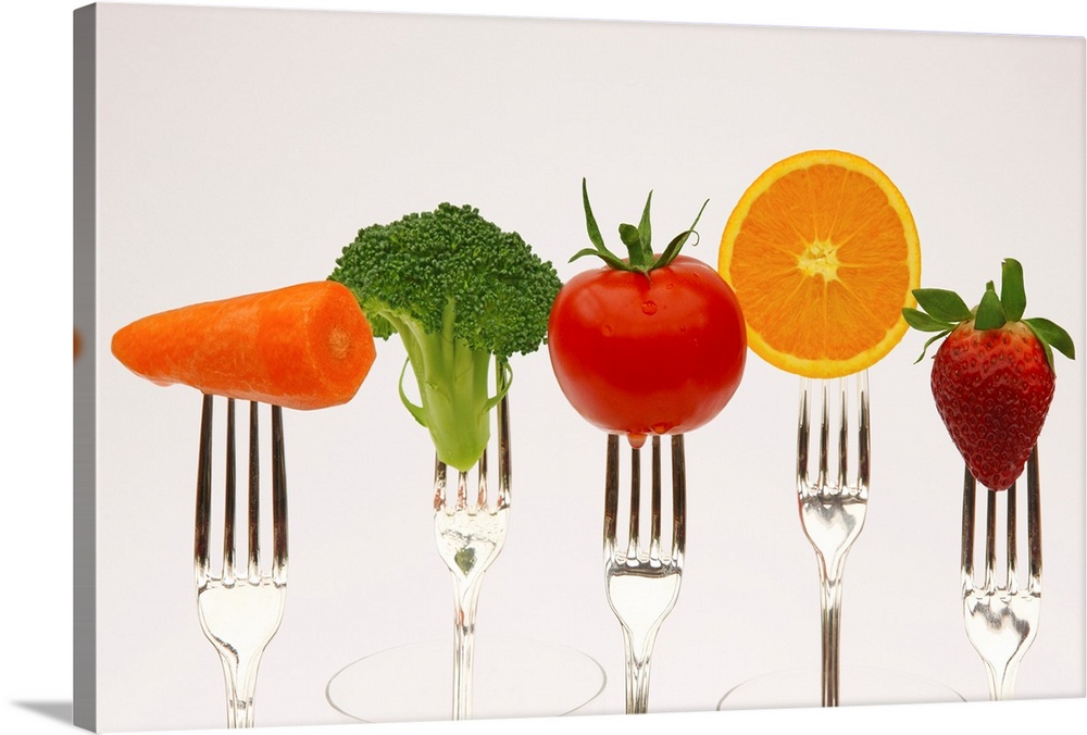 Five fresh fruits and vegetables to be used as your five-a-day, on the prongs of forks, with a white background.