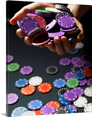 Person holding handful of gambling chips, close-up