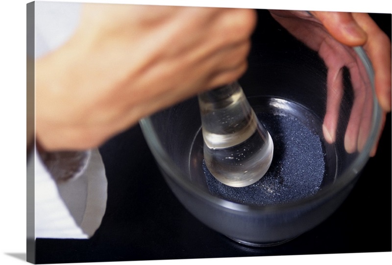 Pharmacist using mortar and pestle on table, close-up, elevated view